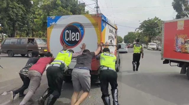 Satlantas Polres Sumenep Dorong Mobil Mogok di Tengah Jalan
